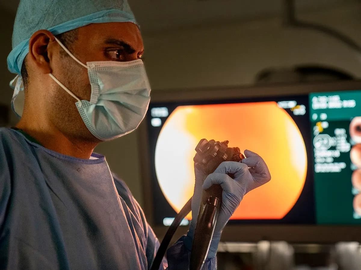 Gastro-entérologue tenant l'endoscope devant l'écran de l'examen