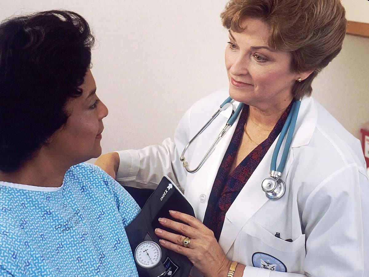 Médecin prenant la tension artérielle d'une patiente en consultation