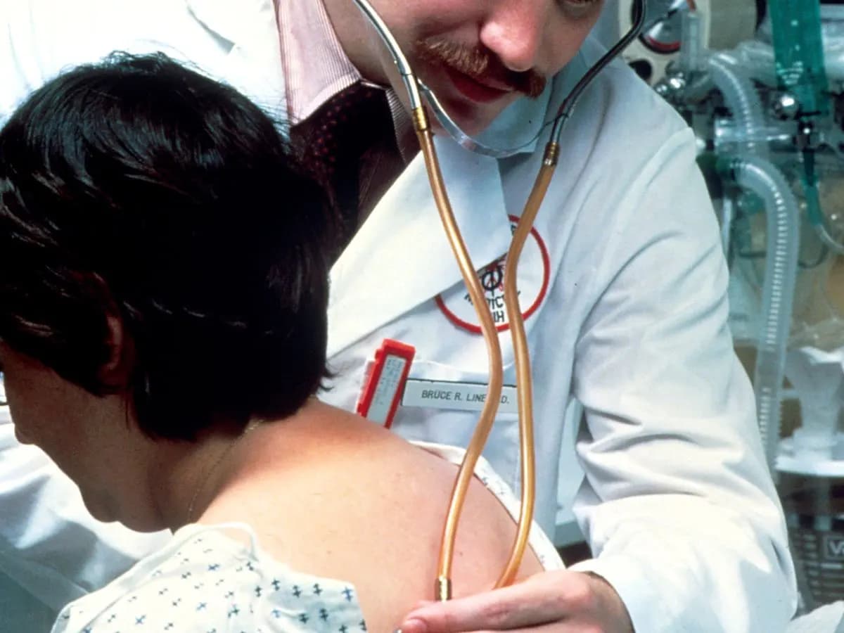 Médecin auscultant les poumons d'une patiente au stéthoscope
