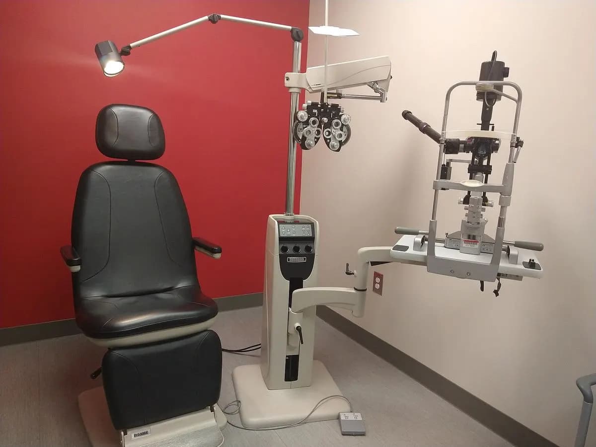 Salle d'examen ophtalmologique : fauteuil, lampe à fente et réfracteur